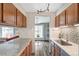 Well-lit kitchen featuring wood cabinets, granite countertops, stainless steel sink, and mosaic tile backsplash at 8424 Everett Way # A, Arvada, CO 80005