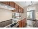 Kitchen showcasing a stainless steel stove top, wood cabinets, granite countertops, and a window view to the living room at 8424 Everett Way # A, Arvada, CO 80005