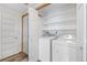 Neat laundry area with a washer, a dryer, shelving, and vinyl flooring at 8424 Everett Way # A, Arvada, CO 80005