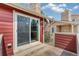 Cozy patio with sliding door, stone chimney, and privacy fence for outdoor enjoyment at 8424 Everett Way # A, Arvada, CO 80005