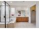 A bathroom features a large tub, a large mirror, a glass door, and tile flooring at 17138 Moorside Dr, Parker, CO 80134