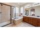 A bathroom features a large tub, a shower, a large mirror, a glass door, and tile flooring at 17138 Moorside Dr, Parker, CO 80134