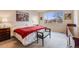 A bedroom features a large window, carpet, and a queen-sized bed with a red and white comforter at 17138 Moorside Dr, Parker, CO 80134