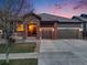 Charming single-Gathering home boasts a brick facade, three-car garage, and mature landscaping during a colorful sunset at 17138 Moorside Dr, Parker, CO 80134