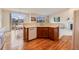 A full shot of the kitchen with wooden cabinets and a half-wall separating the living room at 17138 Moorside Dr, Parker, CO 80134