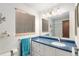 Bright bathroom with a blue countertop, modern fixtures, tiled walls, and a framed mirror at 7622 E Nassau Ave, Denver, CO 80237