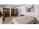 Bedroom featuring a large bed, a dresser, curtains, and an attached bathroom at 7622 E Nassau Ave, Denver, CO 80237