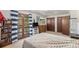 Spacious bedroom with a large bed, wood bookcase, curtains, and private outdoor balcony access at 7622 E Nassau Ave, Denver, CO 80237