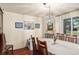 Elegant dining room featuring wood floors, sophisticated chandelier, and large window at 7622 E Nassau Ave, Denver, CO 80237