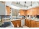 Cozy kitchen features wood cabinets, ample counter space, a double sink, and modern lighting at 7622 E Nassau Ave, Denver, CO 80237