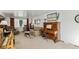 Cozy living room featuring carpet, seating, and a beautiful piano at 7622 E Nassau Ave, Denver, CO 80237