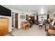 Bright living room with a large window, carpet, and multiple sitting areas at 7622 E Nassau Ave, Denver, CO 80237
