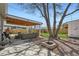 Inviting backyard with a covered patio, fire pit area and mature trees at 3180 Mowry Pl, Westminster, CO 80031