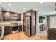 Stylish kitchen with stainless steel appliances, dark cabinets, and a view into the adjacent living area at 3180 Mowry Pl, Westminster, CO 80031
