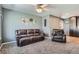 Cozy living room with soft carpeting, a comfortable leather sofa, and a decorative 'HOME' wall art at 3180 Mowry Pl, Westminster, CO 80031