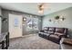 Comfortable living room featuring plush carpeting, a leather sofa, and a view of the front yard at 3180 Mowry Pl, Westminster, CO 80031