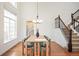 Dining room with hardwood floors, modern chandelier, and adjacent staircase. Large window at 10222 Gemstone Ct, Parker, CO 80134