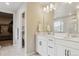 Bright bathroom with dual vanity sinks, matte black hardware, white cabinets, and a walk-in closet at 9807 Rosalee Peak St, Littleton, CO 80125