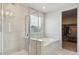 Elegant bathroom featuring a glass-enclosed shower, a large soaking tub, and a walk-in closet at 9807 Rosalee Peak St, Littleton, CO 80125