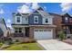 Two-story home featuring brick details and a white garage door with well-maintained landscaping at 9807 Rosalee Peak St, Littleton, CO 80125