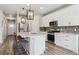 Modern kitchen featuring white cabinets, stainless steel appliances, and a center island with seating at 9807 Rosalee Peak St, Littleton, CO 80125