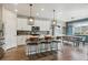 Bright kitchen with white cabinets, a center island with seating, and modern pendant lighting at 9807 Rosalee Peak St, Littleton, CO 80125