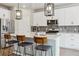 Modern kitchen featuring white cabinets, stainless steel appliances, and island seating with pendant lights at 9807 Rosalee Peak St, Littleton, CO 80125