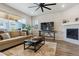 Cozy living room with a fireplace, plush sofa, and large windows offering plenty of light at 9807 Rosalee Peak St, Littleton, CO 80125
