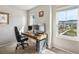 Bright home office with a window view, complete with a computer setup and comfortable seating at 9807 Rosalee Peak St, Littleton, CO 80125