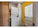 Laundry area with stacked washer and dryer, adjacent to a bright yellow wall and a doorway at 1439 Dexter St, Denver, CO 80220