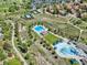Aerial view of community amenities, including a pool, tennis courts, and walking paths surrounded by lush greenery at 8182 Sweet Water Rd, Lone Tree, CO 80124