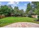 Large, grassy backyard enclosed by a wooden fence with lush greenery and a patio at 8182 Sweet Water Rd, Lone Tree, CO 80124