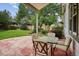 Covered backyard patio with dining table and chairs surrounded by a lush, green yard at 8182 Sweet Water Rd, Lone Tree, CO 80124