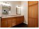 Well-lit bathroom featuring double sinks, granite counters, wood cabinets, and a modern design at 8182 Sweet Water Rd, Lone Tree, CO 80124
