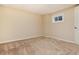 Neutral carpeted bedroom with a small window and white door, offering a blank canvas for personalization at 8182 Sweet Water Rd, Lone Tree, CO 80124