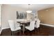 Well-lit dining room with a chandelier over a dark wood table and comfortable upholstered chairs at 8182 Sweet Water Rd, Lone Tree, CO 80124