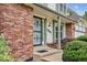 Front porch with brick detail, green trim, secure front door and manicured bushes at 8182 Sweet Water Rd, Lone Tree, CO 80124