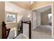 Upstairs hallway featuring wood railing, chandelier, and view of the front door below at 8182 Sweet Water Rd, Lone Tree, CO 80124