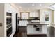 Modern kitchen features stainless steel appliances, white cabinets and center island with cooktop at 8182 Sweet Water Rd, Lone Tree, CO 80124