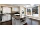 Bright kitchen features a center island with cooktop, stainless appliances, and a view of the backyard at 8182 Sweet Water Rd, Lone Tree, CO 80124