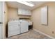 Convenient laundry room is equipped with a washer, dryer, utility sink, and upper cabinets at 8182 Sweet Water Rd, Lone Tree, CO 80124
