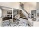 Bright living room featuring a high ceiling, elegant staircase, and open layout to the dining area, perfect for gatherings at 8182 Sweet Water Rd, Lone Tree, CO 80124