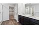 Bathroom featuring double sinks, dark cabinetry, and a step-in shower and walk-in closet at 14412 Heritage Dr, Mead, CO 80504