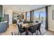 Modern dining area with gray chairs, a wooden table, and an open view to the kitchen. Sliding glass door at 14412 Heritage Dr, Mead, CO 80504