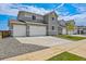 Charming gray home with three-car garage, manicured lawn, and neighboring houses, showcasing a Gathering-friendly community at 14412 Heritage Dr, Mead, CO 80504