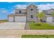 Inviting two-story home featuring a gray exterior, well-maintained lawn, and a spacious three-car garage at 14412 Heritage Dr, Mead, CO 80504