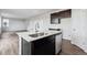 The kitchen island features a stainless steel sink, white countertop, and dark cabinetry with modern appliances at 14412 Heritage Dr, Mead, CO 80504
