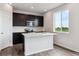 Modern kitchen with dark cabinets, stainless steel appliances, and a bright white countertop island at 14412 Heritage Dr, Mead, CO 80504