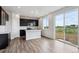 Contemporary kitchen featuring dark cabinetry, a white island, modern appliances, and sliding glass doors with outdoor views at 14412 Heritage Dr, Mead, CO 80504
