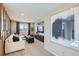 Bright living room with a white sectional sofa, large window with a view, and modern decor at 14412 Heritage Dr, Mead, CO 80504